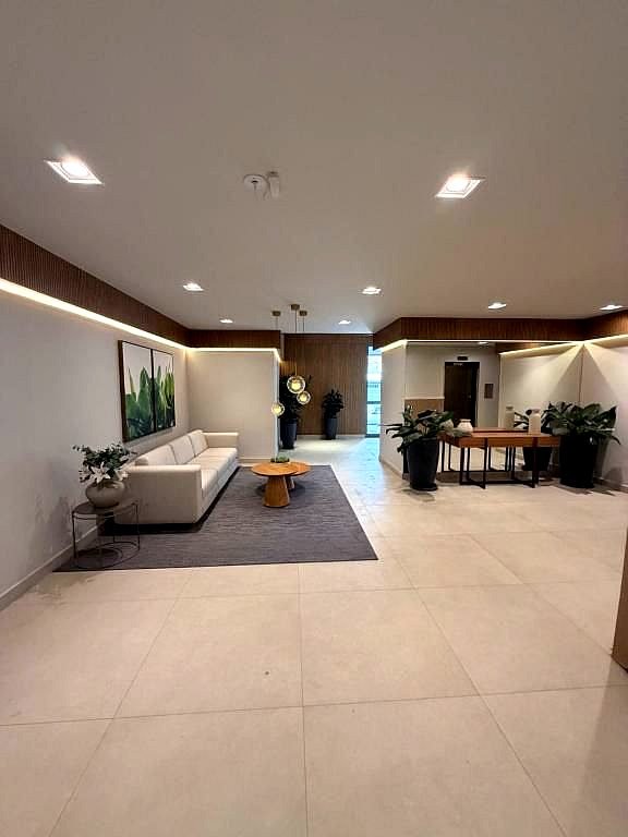 Hall de entrada do Madre 914 com sofá e mesa de apoio